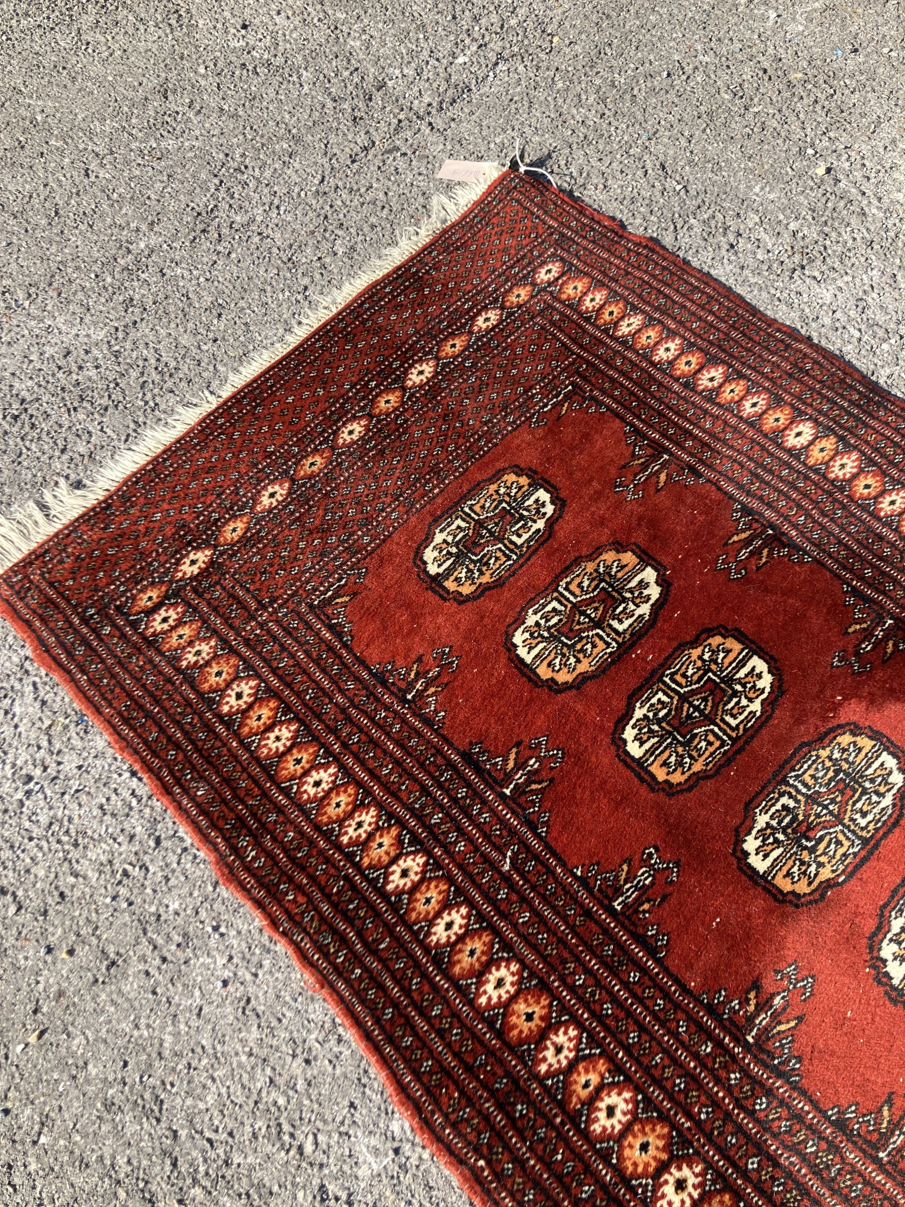 A Bokhara red ground runner with multi medallion field, 326 x 80cm